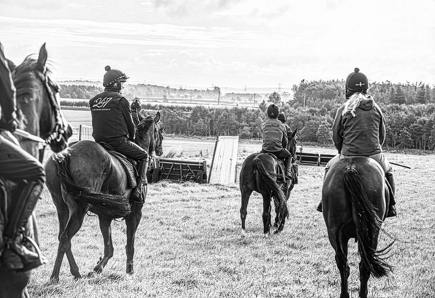 Racehorses and riders walking out together on the morning gallop